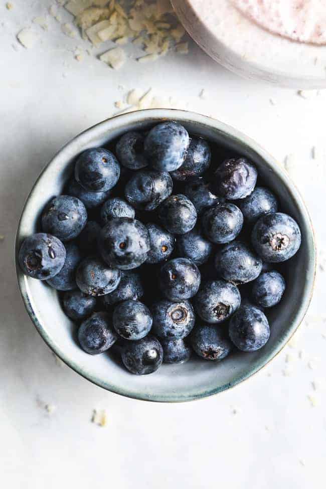 bowl of fresh blueberries on a white table