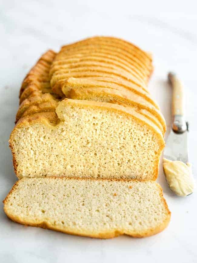 loaf of sliced keto coconut bread with a knife