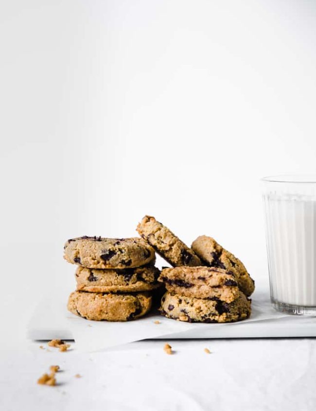 keto pumpkin chocolate chip cookies with milk on white background
